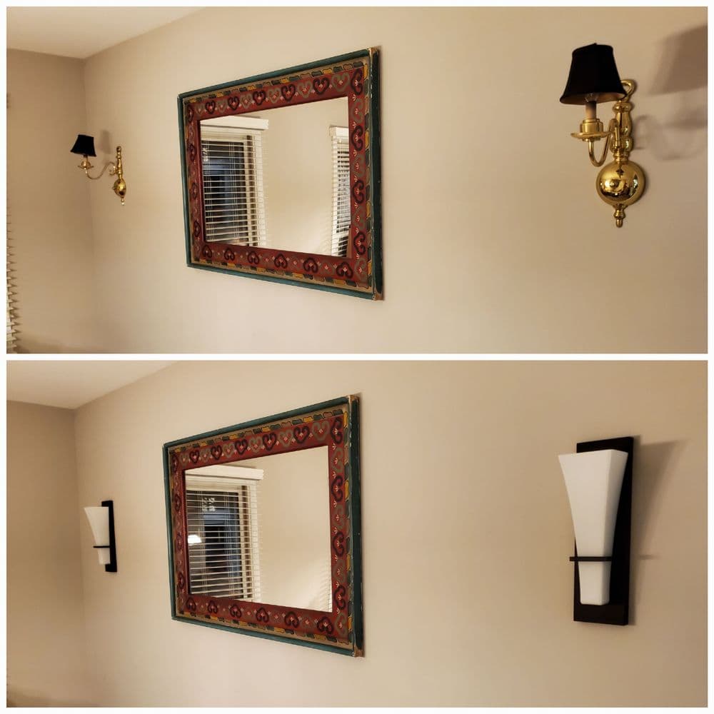 Decorative wall mirror with ornate frame, complemented by stylish wall sconces.